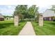 Community green space with walkway and decorative stone pillars at 6816 Minnow Dr, Indianapolis, IN 46237