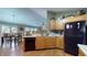A spacious kitchen, with stainless steel sink, wood cabinets, and black appliances with durable flooring throughout at 6816 Minnow Dr, Indianapolis, IN 46237