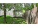 Backyard shed with a small deck and a white door, set against a backdrop of lush greenery and a fence at 6816 Minnow Dr, Indianapolis, IN 46237