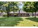 Manicured backyard with lush green grass and mature trees surrounding the brick home at 770 Viewpoint Dr, Plainfield, IN 46168