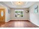 Well-lit dining room with hardwood floors and a large window overlooking the front yard at 770 Viewpoint Dr, Plainfield, IN 46168