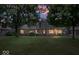 This brick home's backyard is framed by mature trees under a vibrant dusk sky at 770 Viewpoint Dr, Plainfield, IN 46168