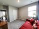 Cozy bedroom with a red sofa, large window, and neutral walls, perfect for relaxation at 7808 Grande Oaks Dr, Plainfield, IN 46168