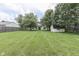 Expansive backyard featuring a well-maintained lawn, mature trees, and a storage shed, perfect for outdoor activities at 7914 Willow Wind Cir, Indianapolis, IN 46239