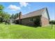 Beautiful backyard showcasing a brick home with a well-kept lawn, mature trees, and a fenced area for added privacy at 8030 5 Points Rd, Indianapolis, IN 46259