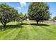 Expansive green backyard with mature trees with a house in the background at 8030 5 Points Rd, Indianapolis, IN 46259