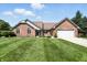 Well maintained brick home with an attached two-car garage and a lush green lawn, offering curb appeal at 8030 5 Points Rd, Indianapolis, IN 46259
