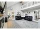 Bright open living room with a cathedral ceiling, fireplace, black leather sofas, and gray area rug at 8030 5 Points Rd, Indianapolis, IN 46259