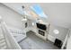 Bright living room boasts a fireplace, high ceilings, skylights, ceiling fan, and wood-look flooring at 8030 5 Points Rd, Indianapolis, IN 46259
