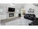 Bright living room with a fireplace, large TV, and grey accent wall and gray, patterned area rug at 8030 5 Points Rd, Indianapolis, IN 46259