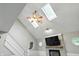 Bright living room featuring vaulted ceilings, skylights, a staircase, and a fireplace with mounted flat screen TV at 8030 5 Points Rd, Indianapolis, IN 46259