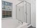 Elegant bathtub with a separate glass enclosed shower and natural light from the window at 9046 Sparta Dr, Fishers, IN 46038