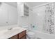Clean bathroom featuring a shower with a patterned curtain, a well-lit mirror and wooden cabinets at 9046 Sparta Dr, Fishers, IN 46038
