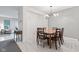 Dining room features a light gray wall and a wooden table with six chairs, looking into a living room at 9046 Sparta Dr, Fishers, IN 46038