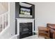 Elegant black fireplace with white mantle and a modern flat-screen TV mounted above, with a staircase to the left at 9046 Sparta Dr, Fishers, IN 46038