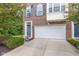 A brick townhome with an attached garage, a well-maintained lawn, and a charming front door entrance at 9046 Sparta Dr, Fishers, IN 46038