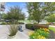 A front yard with flowering plants and greenery, a walkway that leads to the front door and a peek at the neighbor's townhome at 9046 Sparta Dr, Fishers, IN 46038
