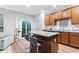 Open kitchen features a granite-topped island with seating, wood cabinets, and a sliding glass door with natural light at 9046 Sparta Dr, Fishers, IN 46038