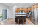 Modern kitchen with stainless steel appliances, an island with seating, wood cabinets, and a sliding glass door at 9046 Sparta Dr, Fishers, IN 46038
