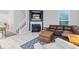 Cozy living room with fireplace, TV, leather sectional, ottoman, side tables, and a stylish geometric rug at 9046 Sparta Dr, Fishers, IN 46038