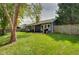 Lush backyard featuring a well-maintained lawn, wood fence, and charming pergola-covered deck with outdoor furniture at 9170 Andiron Way, Indianapolis, IN 46250