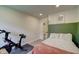 Bright bedroom with a Peloton bike, half-painted accent wall, and plush bedding, creating a modern and inviting space at 9170 Andiron Way, Indianapolis, IN 46250
