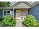 Charming home entrance featuring stone accents, a bright yellow door, and lush landscaping at 9170 Andiron Way, Indianapolis, IN 46250