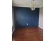 Dining room features wood-look floors and a patterned navy blue accent wall with modern chandelier at 922 Eagle Brook Dr, Shelbyville, IN 46176