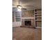 Cozy living room showcases a brick fireplace flanked by white built-in shelves and cabinets at 922 Eagle Brook Dr, Shelbyville, IN 46176