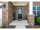 Inviting front porch with brick accents, a stylish front door, and manicured landscaping at 9407 Casey Rd, Pendleton, IN 46064