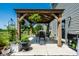 Outdoor gazebo with table and chairs next to house, surrounded by green plants and pots at 9407 Casey Rd, Pendleton, IN 46064