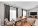 Bright dining area features a stylish table, comfortable seating, and large windows with elegant curtains at 9858 Bryce Blvd, Pendleton, IN 46064