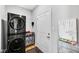 Functional laundry room with a stacked washer and dryer, storage shelves, and convenient access to the backyard at 9858 Bryce Blvd, Pendleton, IN 46064