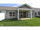 Home featuring a covered patio, a grassy yard, and large windows for natural light at 10602 Maidenhair Dr, Indianapolis, IN 46239
