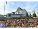 Welcoming Sagebrook West community sign with colorful flowers and a glimpse of a beautiful home at 10602 Maidenhair Dr, Indianapolis, IN 46239