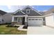 Charming home featuring stone accents, gray siding, and a convenient two-car garage at 10602 Maidenhair Dr, Indianapolis, IN 46239