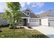 Charming home featuring stone accents, gray siding, and a convenient two-car garage at 10602 Maidenhair Dr, Indianapolis, IN 46239