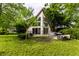 Picturesque backyard featuring mature trees, a lush lawn, a patio with hot tub, and an architectural house at 11544 Crestwood Ct, Indianapolis, IN 46239