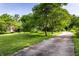 A long driveway leads to a well maintained front yard with verdant grass and mature shade trees at 11544 Crestwood Ct, Indianapolis, IN 46239