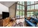 Bright living room with hardwood floors, TV, and large windows offering a scenic view of the outdoors at 11544 Crestwood Ct, Indianapolis, IN 46239