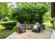 Relaxing patio featuring comfortable seating amidst lush greenery with flowerbed, perfect for enjoying the outdoors at 11544 Crestwood Ct, Indianapolis, IN 46239