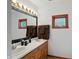 Bathroom featuring a double sink, cabinet, mirror, lighting, and a window at 1224 S Hunter Rd, Indianapolis, IN 46239