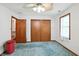 Bright bedroom with a ceiling fan, closet, and blue carpet at 1224 S Hunter Rd, Indianapolis, IN 46239