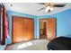 This bedroom features a large closet, blue walls, and a ceiling fan at 1224 S Hunter Rd, Indianapolis, IN 46239