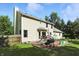 Back exterior view of the home featuring a brick patio and large green lawn at 1224 S Hunter Rd, Indianapolis, IN 46239