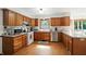 Well-lit kitchen with stainless steel appliances, wood cabinets, and a tiled backsplash and flooring at 1224 S Hunter Rd, Indianapolis, IN 46239
