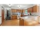 Bright eat-in kitchen with stainless steel appliances, wood cabinets, and an attached breakfast bar at 1224 S Hunter Rd, Indianapolis, IN 46239