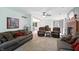 Open-concept living room with neutral carpeting and views into eat-in kitchen and backyard at 1224 S Hunter Rd, Indianapolis, IN 46239