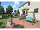 Brick patio area with a swing, steps to the yard, and views of a lush green backyard at 1224 S Hunter Rd, Indianapolis, IN 46239
