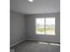 Carpeted bedroom with a large window offering natural light and neutral walls with white trim at 12400 French Cattle Way, Noblesville, IN 46060